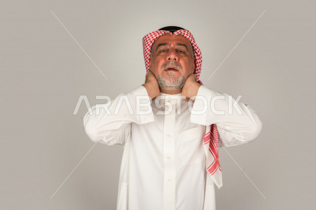 بورتريه لرجل كبير بالسن سعودي خليجي  مريض بإيماءات الوجه و اليدين التي تدل على الألم والمعاناه،  تعابير وجه ، خلفية بيضاء