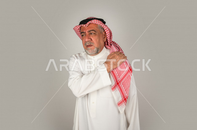 بورتريه لرجل كبير بالسن سعودي خليجي  مريض بإيماءات الوجه و اليدين التي تدل على الألم والمعاناه،  تعابير وجه ، خلفية بيضاء