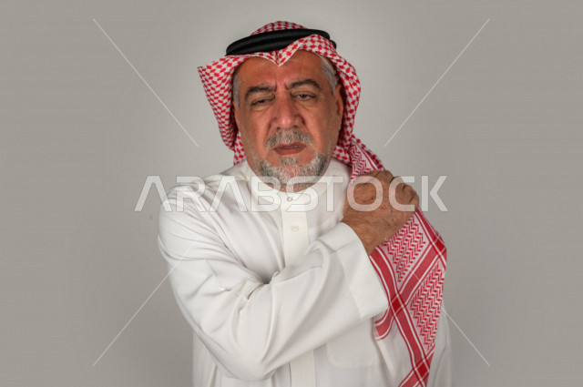بورتريه لرجل كبير بالسن سعودي خليجي  مريض بإيماءات الوجه و اليدين التي تدل على الألم والمعاناه،  تعابير وجه ، خلفية بيضاء