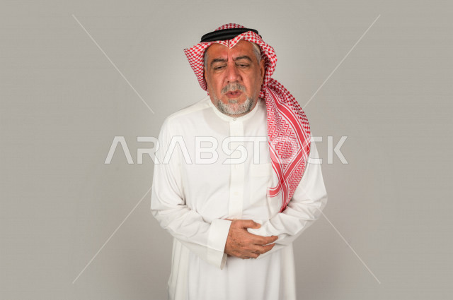 بورتريه لرجل كبير بالسن سعودي خليجي  مريض بإيماءات الوجه و اليدين التي تدل على الألم والمعاناه،  تعابير وجه ، خلفية بيضاء