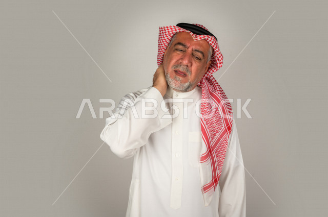 بورتريه لرجل كبير بالسن سعودي خليجي  مريض بإيماءات الوجه و اليدين التي تدل على الألم والمعاناه،  تعابير وجه ، خلفية بيضاء