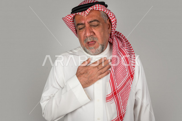 بورتريه لرجل كبير بالسن سعودي خليجي  مريض بإيماءات الوجه و اليدين التي تدل على الألم والمعاناه،  تعابير وجه ، خلفية بيضاء