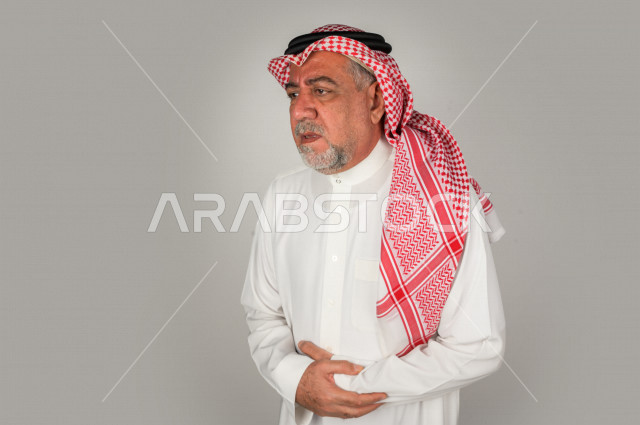 بورتريه لرجل كبير بالسن سعودي خليجي  مريض بإيماءات الوجه و اليدين التي تدل على الألم والمعاناه،  تعابير وجه ، خلفية بيضاء