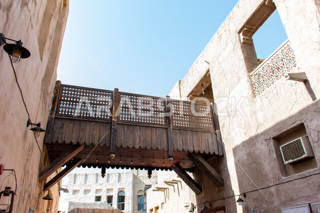 Al Seef Heritage District in Dubai, United Arab Emirates, ancient architectural art, historical landmarks and tourist destinations, a carved wooden fence connecting two mud houses