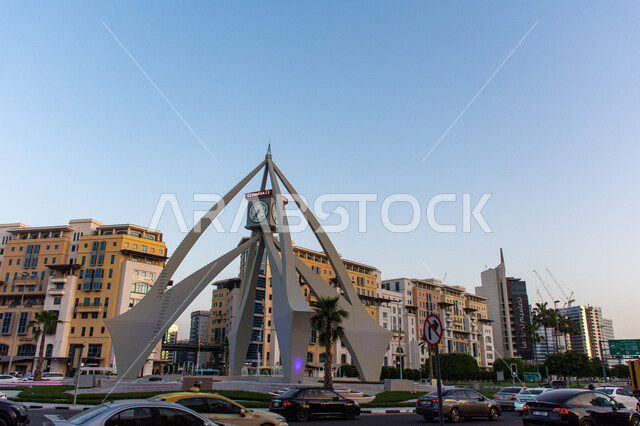 الفن الهندسي المعماري على الطراز الحديث برج الساعه في ديرة في مدينة دبي في وقت النهار ,الحركة المرورية للسيارات في الطرقات والشوارع ,مقصد السياح و الزائرين من مختلف البلدان, أماكن ومعالم سياحية مشهورة ,النمو والتطور العمراني في الامارات العربية المتحدة