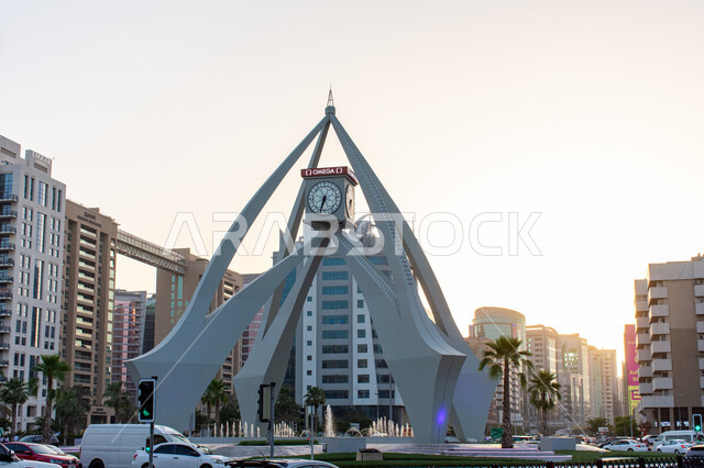 الحركة المرورية للسيارات في الطرقات والشوارع ,مقصد السياح و الزائرين من مختلف البلدان, أماكن ومعالم سياحية مشهورة ,النمو والتطور العمراني في الامارات العربية المتحدة, الفن الهندسي المعماري على الطراز الحديث برج الساعه في ديرة في مدينة دبي في وقت النهار