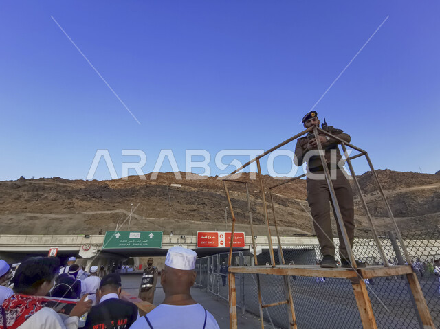 رجل أمن يعمل على مساعدة الحجاج و المعتمرين، لوحات إرشادية في المعالم الإسلامية المشهورة، تجمع المسلمين من شتى أنحاء العالم، أداء مناسك الحج والعمرة في شهر ذي الحجة، العبادة والتقرب إلى الله، الطريق المؤدي لمنطقة رمي الجمرات في مكة المكرمة