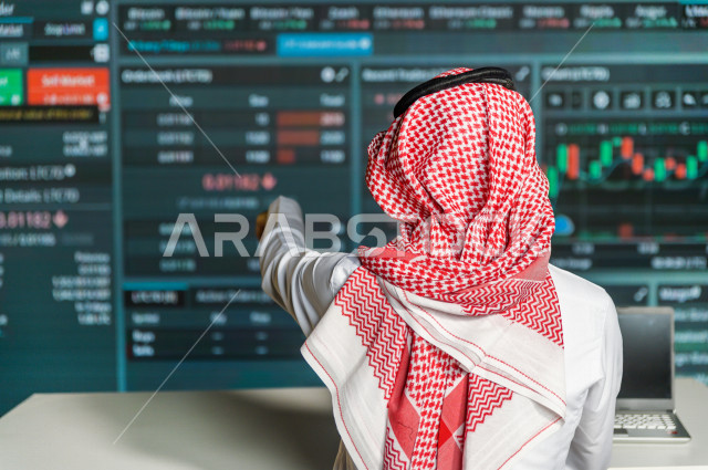 رجل سعودي خليجي يدير القسم الامني  ، يقوم بتتبع كاميرات المراقبة  ، يرتدي الزي السعودي التقليدي ، الحفاظ على الامن و الطمأنينة ، حراسة و امان 