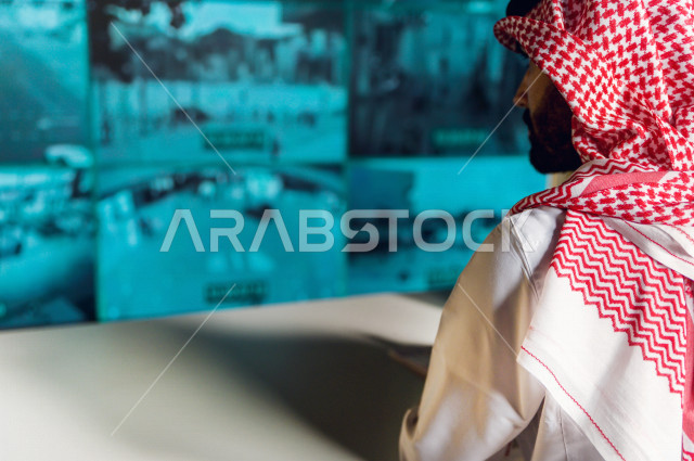 رجل سعودي خليجي يدير القسم الامني  ، يقوم بتتبع كاميرات المراقبة  ، يرتدي الزي السعودي التقليدي ، الحفاظ على الامن و الطمأنينة ، حراسة و امان 
