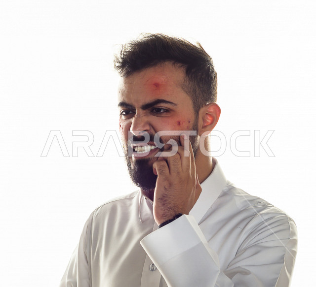 بورتريه لرجل سعودي خليجي مصاب بعدة مشاكل في منطقة الوجه، التعرض للحروق ،  بثور وجه منتشرة على البشرة ، ايماءات و تعبيرات وجه و يدين تدل على الآلم و الحزن ، مشاكل صحية و اصابات جسدية ، خلفية بيضاء