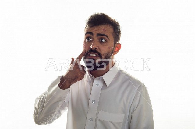 بورتريه لرجل سعودي خليجي مصاب بعدة مشاكل في منطقة الوجه، التعرض للحروق ،  بثور وجه منتشرة على البشرة ، ايماءات و تعبيرات وجه و يدين تدل على الآلم و الحزن ، مشاكل صحية و اصابات جسدية ، خلفية بيضاء
