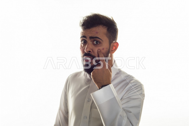 بورتريه لرجل سعودي خليجي مصاب بعدة مشاكل في منطقة الوجه، التعرض للحروق ،  بثور وجه منتشرة على البشرة ، ايماءات و تعبيرات وجه و يدين تدل على الآلم و الحزن ، مشاكل صحية و اصابات جسدية ، خلفية بيضاء