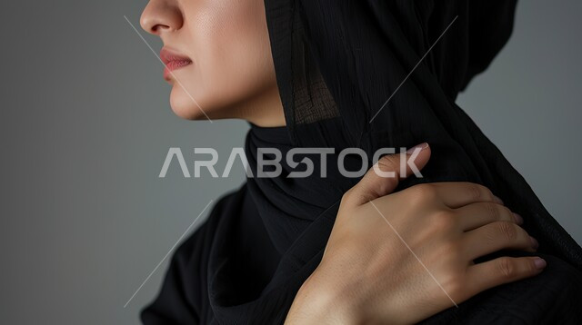 التهاب العضلات والمفاصل والحاجه للعلاج،  المعاناة من الآلام والأوجاع العصبية والعضلية، بورتريه مقرب لإمرأة عربيه سعوديه خليجيه ترتدي العباءة والحجاب تضع يدها على كتفها  بإيماءات الألم والتعب والأرهاق, خلفية رمادية