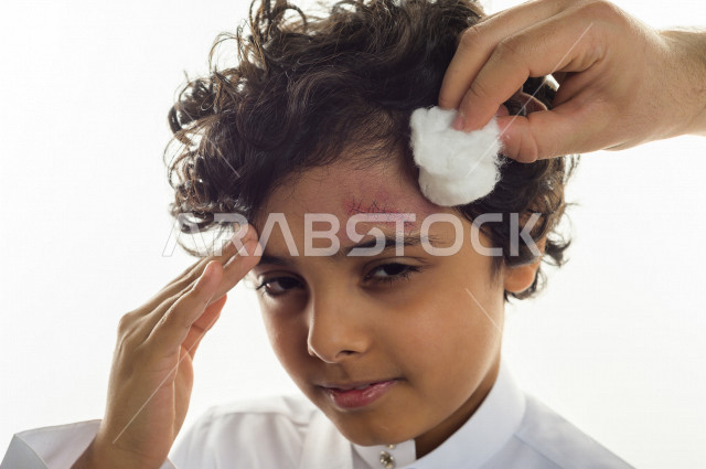 بورتريه لطفل سعودي خليجي مصاب بعدة مشاكل في منطقة الوجه، التعرض للحروق ،  بثور وجه منتشرة على البشرة ، ايماءات و تعبيرات وجه و يدين تدل على الآلم و الحزن ، مشاكل صحية و اصابات جسدية ، خلفية بيضاء