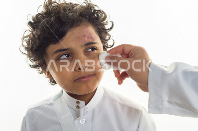 بورتريه لطفل سعودي خليجي مصاب بعدة مشاكل في منطقة الوجه، التعرض للحروق ،  بثور وجه منتشرة على البشرة ، ايماءات و تعبيرات وجه و يدين تدل على الآلم و الحزن ، مشاكل صحية و اصابات جسدية ، خلفية بيضاء