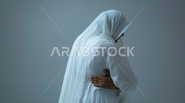التهاب العضلات والمفاصل، الإحساس بالمرض والتعب، بورتريه مقرب من الخلف لامرأه عربيه خليجيه سعوديه ترتدي عباءة بيضاء تضع يدها على خصرها بإيماءات الألم، الحاجه للعلاج وطلب المساعده، خلفية رمادية