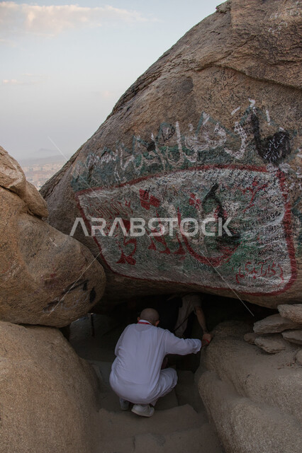 Rock formations and formations in Mecca, a close-up from the back of a man inside the Cave of Thawr, mountain peaks and heights, famous religious landmarks in the Kingdom of Saudi Arabia, Islamic holy places