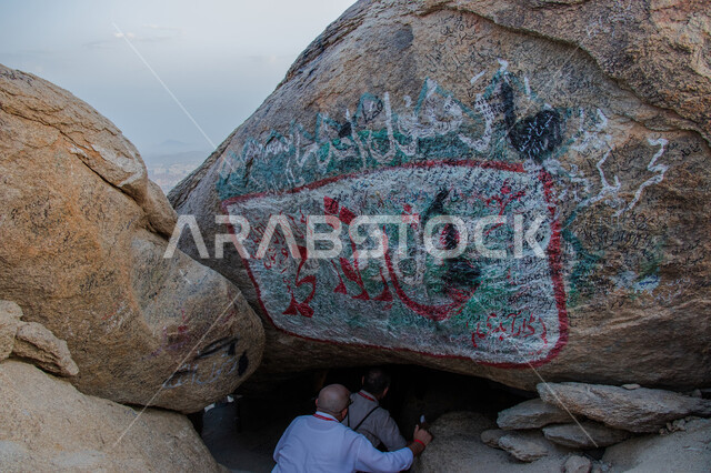 التكوينات والتشكيلات الصخرية في مكة المكرمة، صورة مقربة من الخلف لرجل داخل غار ثور، القمم والمرتفعات الجبلية، معالم دينية مشهورة في المملكة العربية السعودية، أماكن إسلامية مقدسة