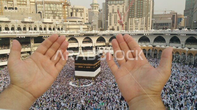 الدعاء والعباده والتقرب الى الله، صورة مقربة لايدي رجل يقوم بالدعاء أمام الكعبة المشرفة، آداء مناسك الحج والعمرة، الركن الخامس من أركان الاسلام، أماكن دينية إسلامية مقدسة في المملكة العربية السعودية