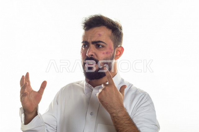 بورتريه لرجل سعودي خليجي مصاب بعدة مشاكل في منطقة الوجه، التعرض للحروق ،  بثور وجه منتشرة على البشرة ، ايماءات و تعبيرات وجه و يدين تدل على الآلم و الحزن ، مشاكل صحية و اصابات جسدية ، خلفية بيضاء