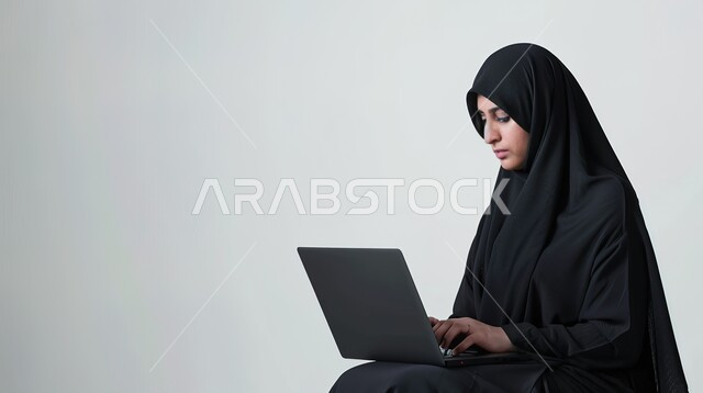 مهن ووظائف نسائية، استخدام التقنيات والاجهزة الحديثة، بورتريه مقرب لامرأة عربية خليجية سعودية تقوم بإستخدام جهاز الحاسوب المحمول، متابعة اهداف ومهام العمل، خلفية بيضاء