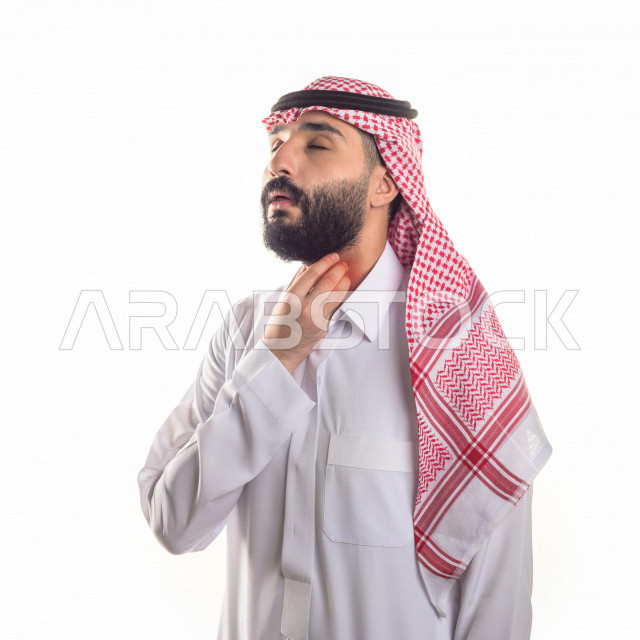 بورتريه لرجل سعودي خليجي مريض بإيماءات الوجه و اليدين التي تدل على الألم والمعاناه ، خلفية بيضاء