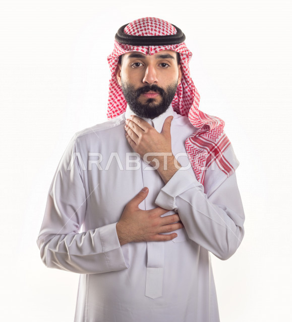 بورتريه لرجل سعودي خليجي مريض بإيماءات الوجه و اليدين التي تدل على الألم والمعاناه ، خلفية بيضاء
