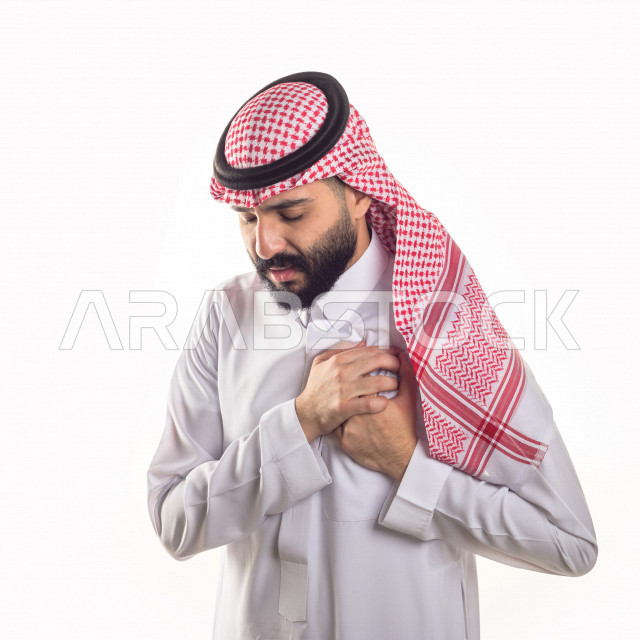 بورتريه لرجل سعودي خليجي مريض بإيماءات الوجه و اليدين التي تدل على الألم والمعاناه ، خلفية بيضاء