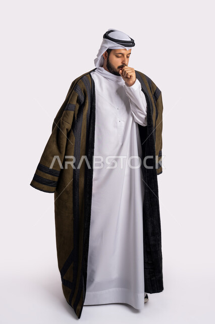 الشعور بالمرض والكحة، الحاجة لتلقي العلاج، الاصابة بفايروس كورونا كوفيد19، الاجواء الشتوية الباردة، الانفلونزا والتهاب الرئة، بورتريه لرجل عربي خليجي اماراتي يرتدي الفروة والغترة البيضاء يعاني من السعال، صورة الجسم بالطول الكامل، خلفية بيضاء