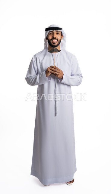 الاحتفال باليوم العالمي للرجل 19 نوفمبر ,  بورتريه لرجل عربي إماراتي خليجي يرتدي الكندورة والغترة البيضاء يحمل بيده قصاصة ورقية على شكل شارب, النظر إلى الكاميرا بإيماءات  الثقة والاعتزاز بالنفس , الاهتمام بصحة الذكور , الطول الكامل للجسم , خلفية بيضاء