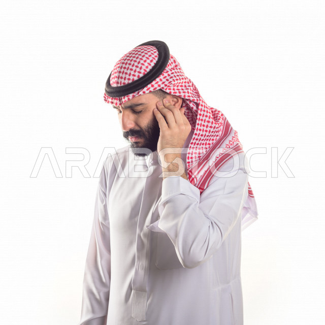 بورتريه لرجل سعودي خليجي يعاني من التهابات الاذن ،بإيماءات الوجه و اليدين التي تدل على الألم والمعاناه ، خلفية بيضاء