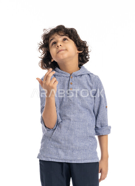 Focus and contemplation to find a solution to a problem, a close-up portrait of an Arab Emirati Gulf boy wearing a casual outfit, placing his hand on his face with gestures to think about something, a Saudi boy meditating and planning for the future, white background