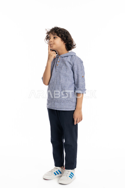 A Saudi boy contemplating and planning for the future, concentrating and contemplating to find a solution to a problem, portrait of an Arab Emirati Gulf boy wearing a casual outfit, placing his hand on his face with gestures to think about something, full body portrait, white background