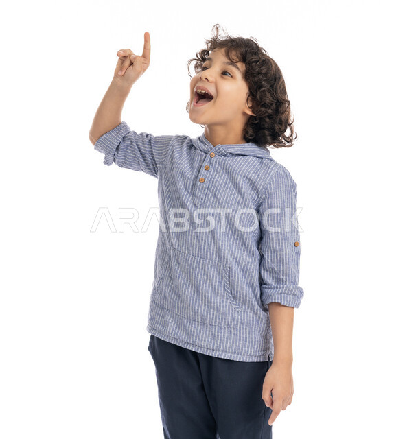 التمعن والتركيز لإيجاد حل لمشكلة، بورتريه مقرب لولد عربي اماراتي خليجي يرتدي الزي الكاجوال يضع يده على وجهه بإيماءات على التفكير بشيء ما, صبي سعودي يقوم بالتأمل والتخطيط للمستقبل, خلفية بيضاء