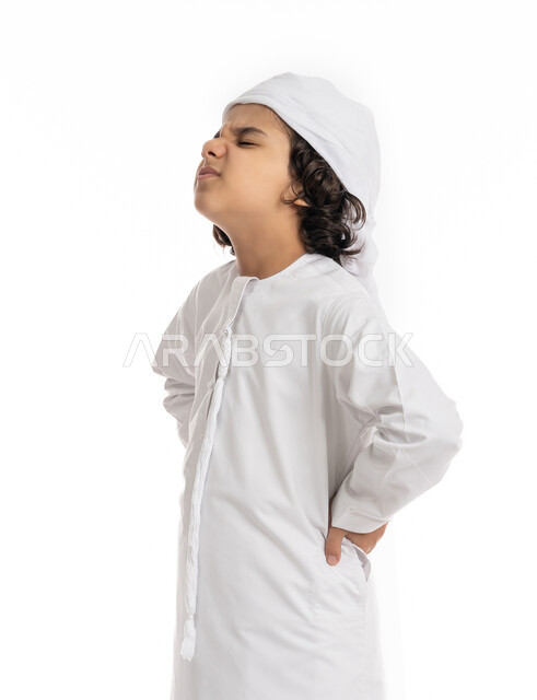 فتى سعودي يعاني من التعب والإرهاق و الحاجه للعلاج، وجع العظام والعضلات, بورتريه مقرب لولد عربي اماراتي سعودي يرتدي العمامة والكندورة, يضع يديه على ظهره بإيماءات تدل على الشعور بالألم, طلب المساعده للذهاب الى الطبيب, خلفية بيضاء