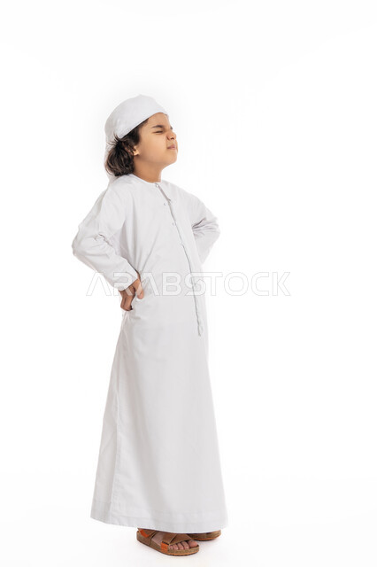 الإحساس بالمرض  ووجع العظام والعضلات, بورتريه لولد عربي اماراتي سعودي يرتدي العمامة والكندورة, يضع يديه على ظهره بإيماءات تدل على الشعور بالألم، فتى سعودي يعاني من التعب والإرهاق و الحاجه للعلاج, طلب المساعده للذهاب الى الطبيب, صورة الجسم بالكامل، خلفية بيضاء