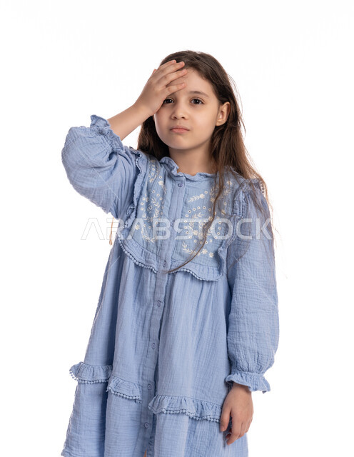 التفكير في شيء ما, طلب المساعده للذهاب الى الطبيب، بورتريه مقرب لفتاة عربيه اماراتية خليجيه تضع يديها على رأسها بايماءات الشعور بالصداع، الإحساس بالمرض و التعب والإرهاق, بنت سعودية ترتدي الفستان بحاجه للعلاج والدواء, خلفية بيضاء