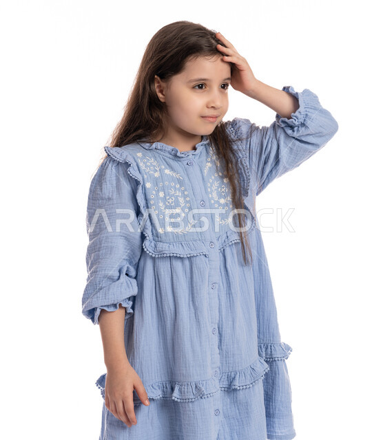 التفكير في شيء ما, طلب المساعده للذهاب الى الطبيب، بورتريه مقرب لفتاة عربيه اماراتية خليجيه تضع يديها على رأسها بايماءات الشعور بالصداع، الإحساس بالمرض و التعب والإرهاق, بنت سعودية ترتدي الفستان بحاجه للعلاج والدواء, خلفية بيضاء