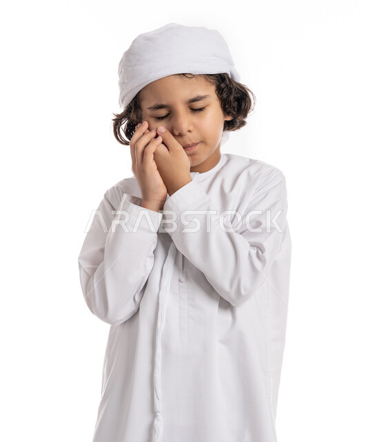 التهاب اللثه وتسوس الأَضراس, الاحتياج الى زيارة طبيب الأسنان، بورتريه مقرب لولد عربي اماراتي خليجي يرتدي الكندورة و العمامة يضع يده على خده بإيماءات تدل على ألم الأسنان, فتى سعودي يعاني من التعب والإرهاق والحاجة لطلب العلاج والمساعده, خلفية بيضاء