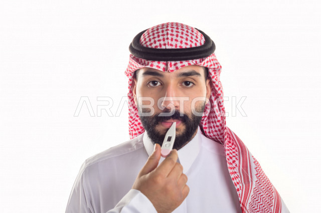 بورتريه لشاب سعودي خليجي يعاني من حمى شديدة ، ،ارتفاع درجات الحرارة ، جهاز قياس درجات الحرارة ، حالة مرضية ،  خلفية بيضاء