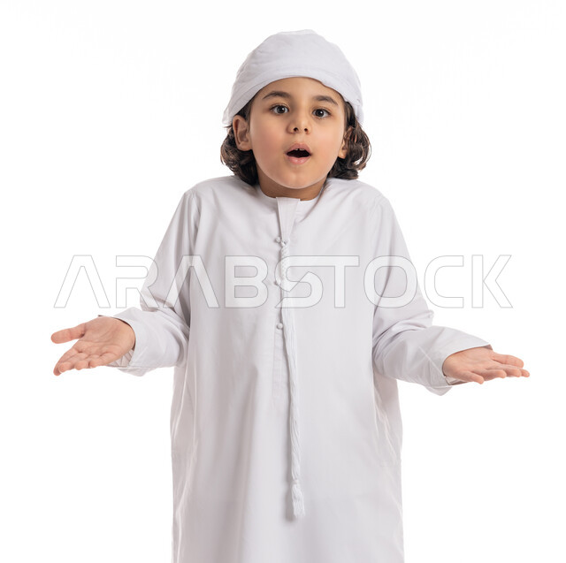 Lack of knowledge and denial, ignorance of the reasons and lack of knowledge, a Saudi boy asking questions about something, a close-up portrait of an Arab Gulf-Emirati boy wearing a turban and kandura with hand gestures expressing “I don’t know,” white background.