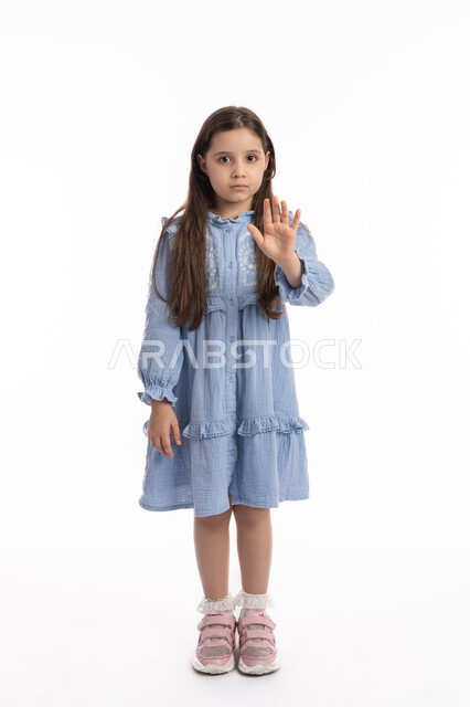 إيماءات يدين تدل على الأمر بالتوقف عن فعل شيء ما و النهي عنه, بنت سعودية ترتدي الفستان و تشعر بالإنزعاج و الرفض والإمتناع، الصمت والتوقف عن الكلام، بورتريه لفتاة عربية اماراتية خليجية ترفع كفها للأعلى, صورة الجسم بالكامل، خلفية بيضاء