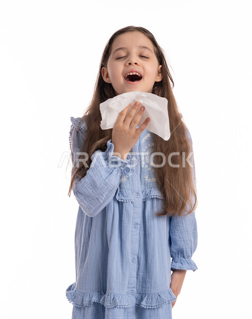 الشعور بالمرض و الزكام, استخدام المناديل الورقيه للعطس, الحاجة الى العلاج والدواء، فتاة سعودية ترتدي الفستان تشعر بالتعب و الارهاق، بورتريه مقرب لفتاة عربيه اماراتية خليجيه بإيماءات وجه ويدين تدل على العطاس, خلفية بيضاء