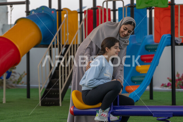 أنشطه ترفيهية مسليه للأطفال، قضاء أوقات ممتعة في الحديقة, التنزه مع الوالدين, مفهوم الأسره السعيده, ايماءات المرح و السرور, استغلال وقت الفراغ في التسلية واللعب, طفلة عربية اماراتية خليجية تلعب في المنتزه, الإستمتاع باللعب في يوم مشمس