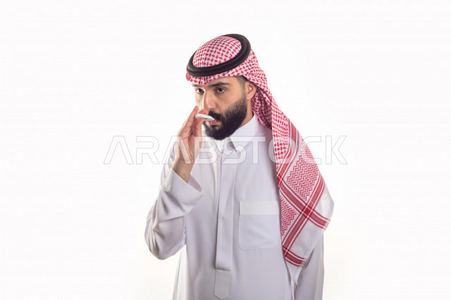 بورتريه لشاب سعودي خليجي يعاني من حمى شديدة ، ،ارتفاع درجات الحرارة ، جهاز قياس درجات الحرارة ، حالة مرضية ،  خلفية بيضاء