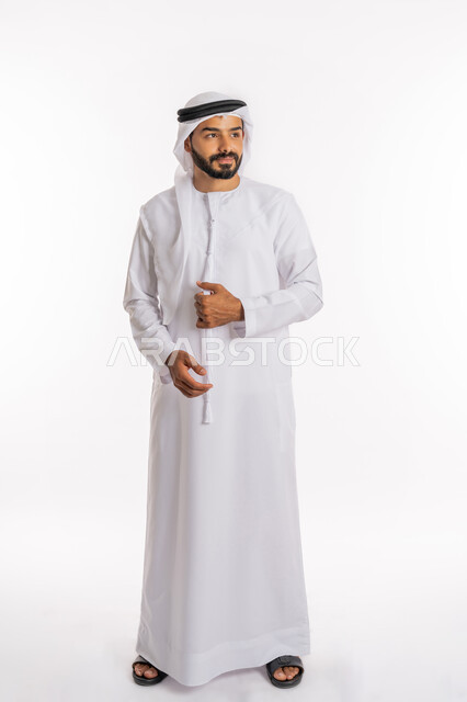 The concept of elegance and masculinity, looking at a place with gestures of contemplation and concentration, expressions of joy and happiness, concern for external appearance, a portrait of an Arab Gulf Emirati man wearing a kandura and a white ghutra adjusting his dress, a full-body portrait, a white background