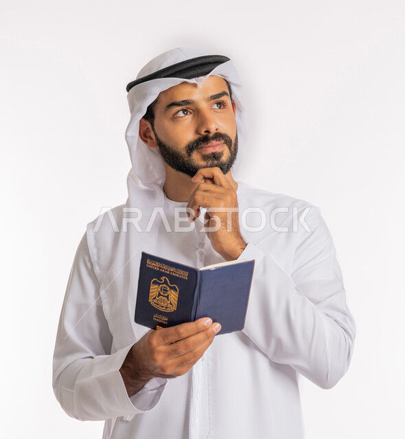 إيماءات الحيرة والتفكير بأمر ما، مفهوم السياحة والسفر، شعار دولة الامارات العربية المتحدة، تأشيرة سفر دولية، بورتريه لرجل عربي خليجي اماراتي يرتدي الكندورة والغترة يضع يده على ذقنه يحمل بيده الباسبور، تعابير البهجة والسرور، خلفية بيضاء