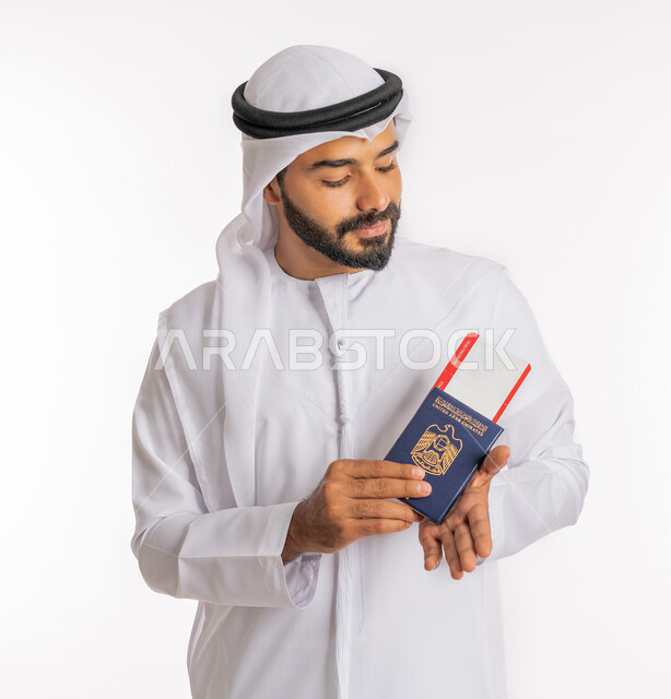 تعابير البهجة والسرور، إيماءات الفرح والسعادة، تأشيرة سفر دولية، شعار دولة الامارات العربية المتحدة، مفهوم السياحة والسفر، بورتريه مقرب لرجل عربي خليجي اماراتي يرتدي الكندورة والغترة يحمل بيده الباسبور وتيكت الطيارة، خلفية بيضاء