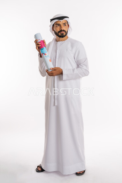 تحديد مسار سير الرحلة، القيام بجولات سياحية ترفيهية، مفهوم السياحة والسفر، البحث والاستكشاف حول العالم، بورتريه لرجل عربي خليجي اماراتي يرتدي الكندورة والغترة يحمل بيده الخريطة، صورة لكامل الجسم، خلفية بيضاء