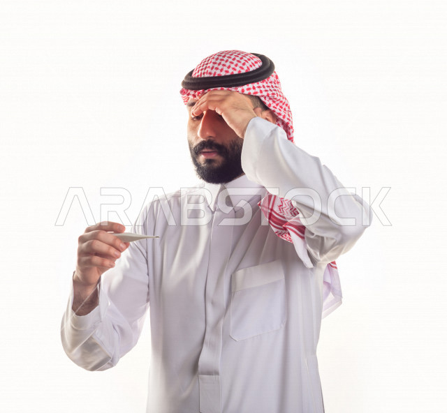 بورتريه لشاب سعودي خليجي يعاني من حمى شديدة ، ،ارتفاع درجات الحرارة ، جهاز قياس درجات الحرارة ، حالة مرضية ،  خلفية بيضاء